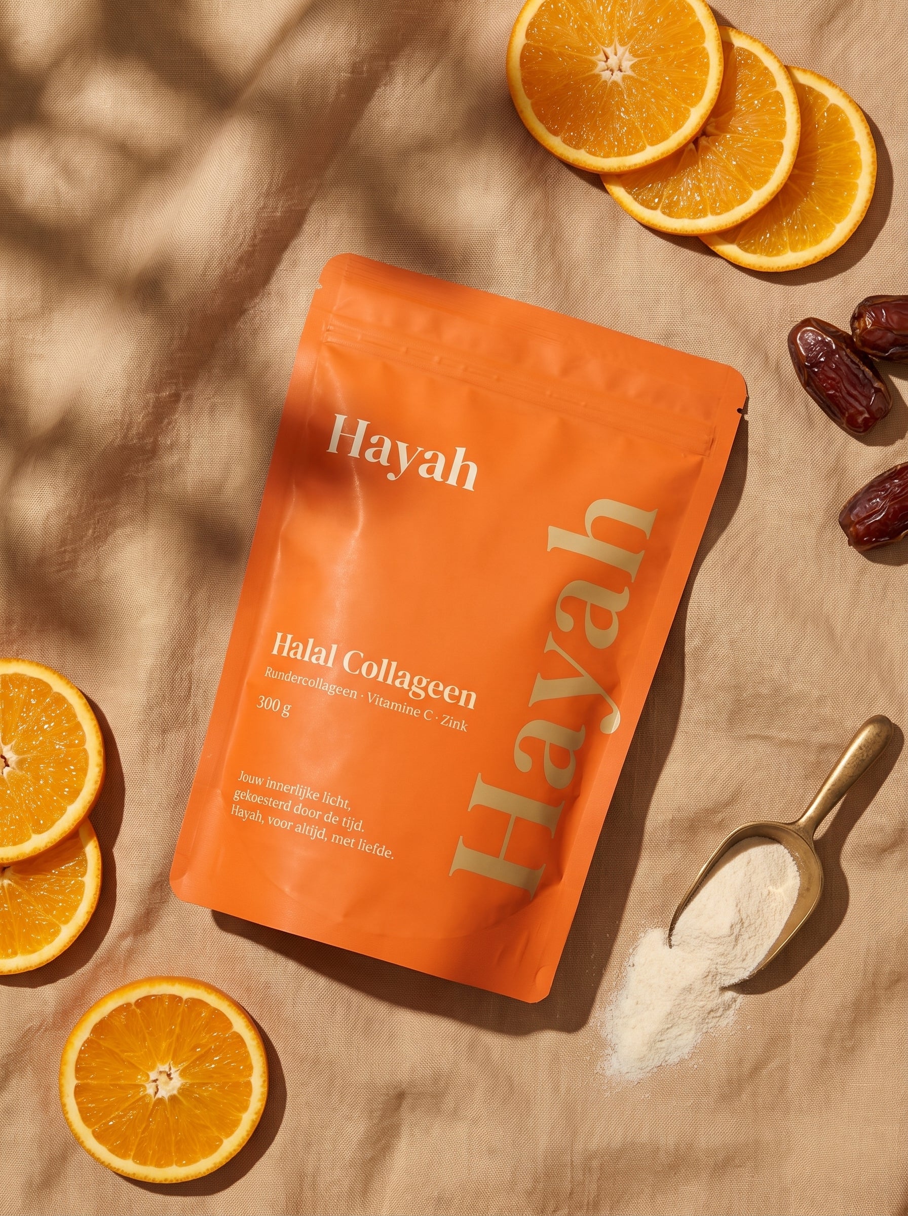Hayah pouch van bovenaf tussen sinaasappels, dadels en een schepje collageen